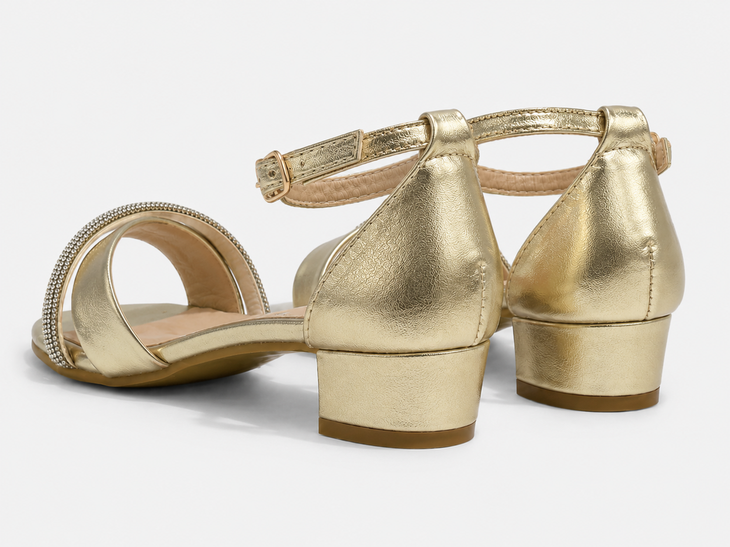 A pair of metallic gold block-heel sandals with an ankle strap and a rhinestone-embellished toe strap, shown from a three-quarters angle on a light gray background.